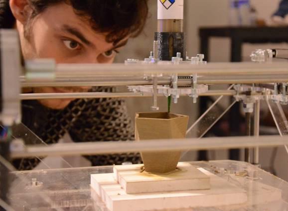 Male student watching 3D printing